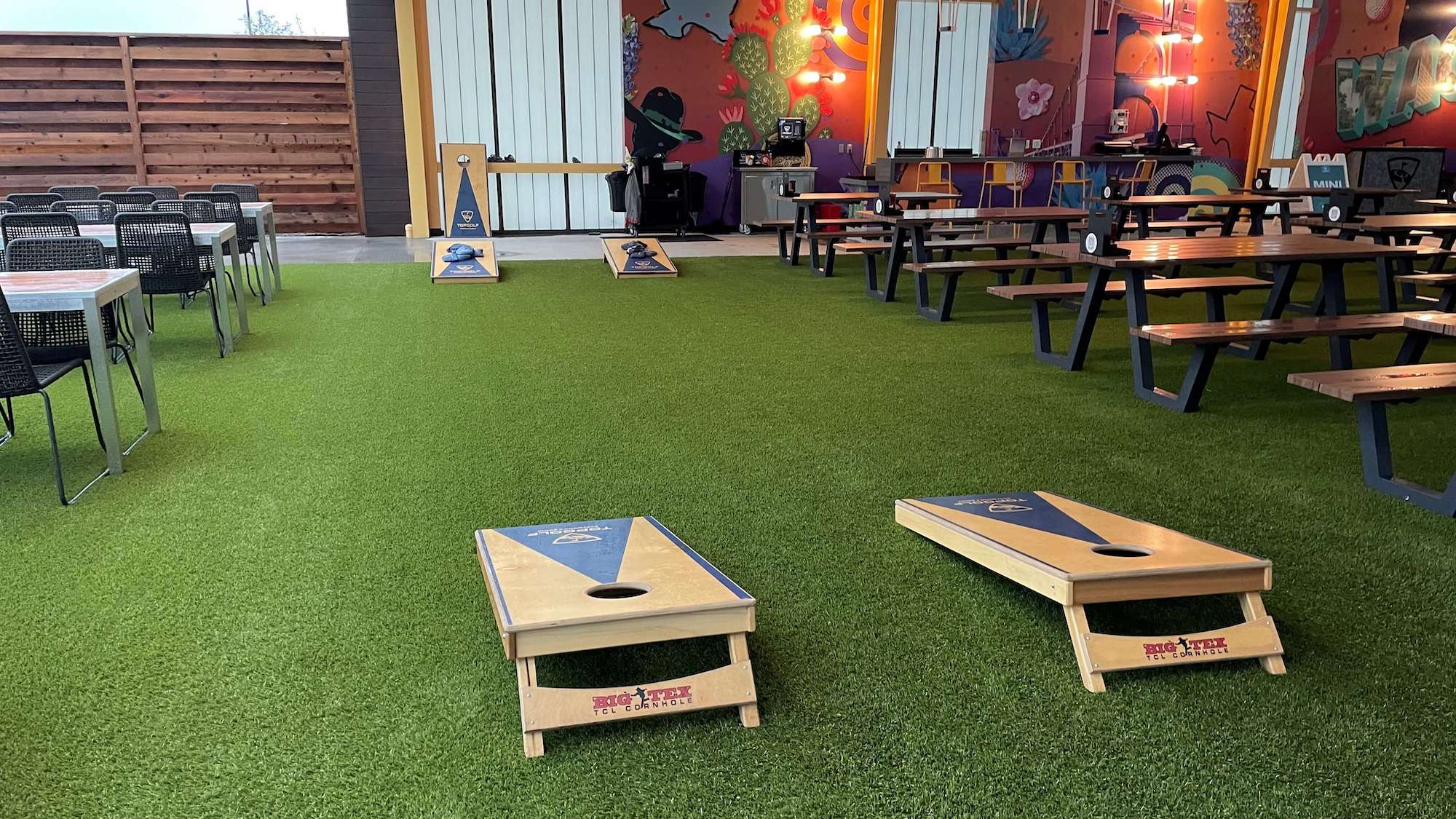 dining area with artificial turf and cornhole